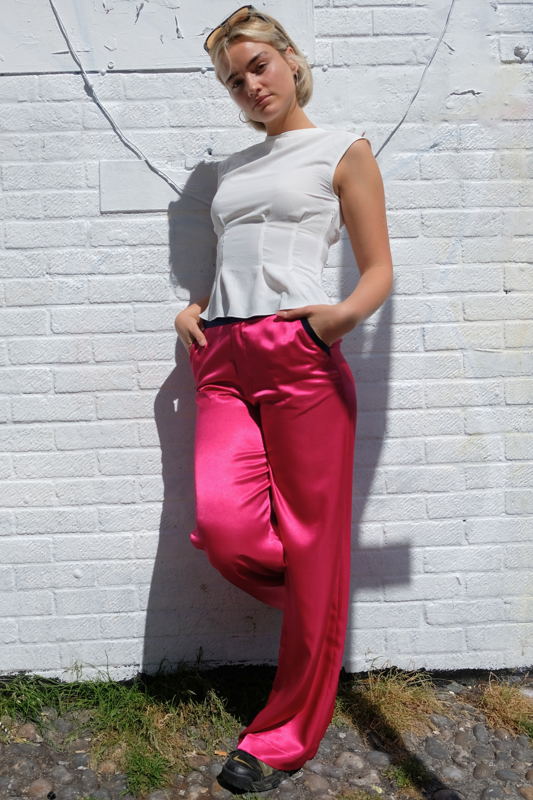 pink wide-leg silk trousers with navy trims, worn in London
