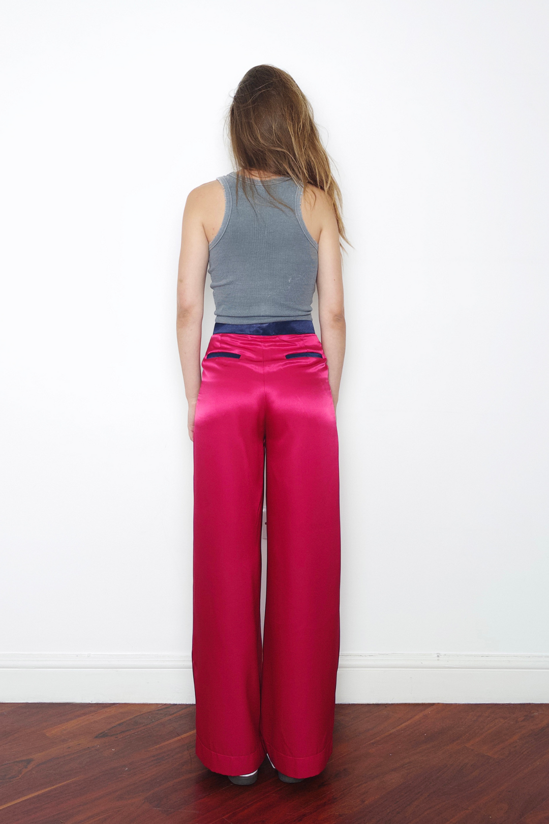 pink wide-leg silk trousers with navy trims, worn in London