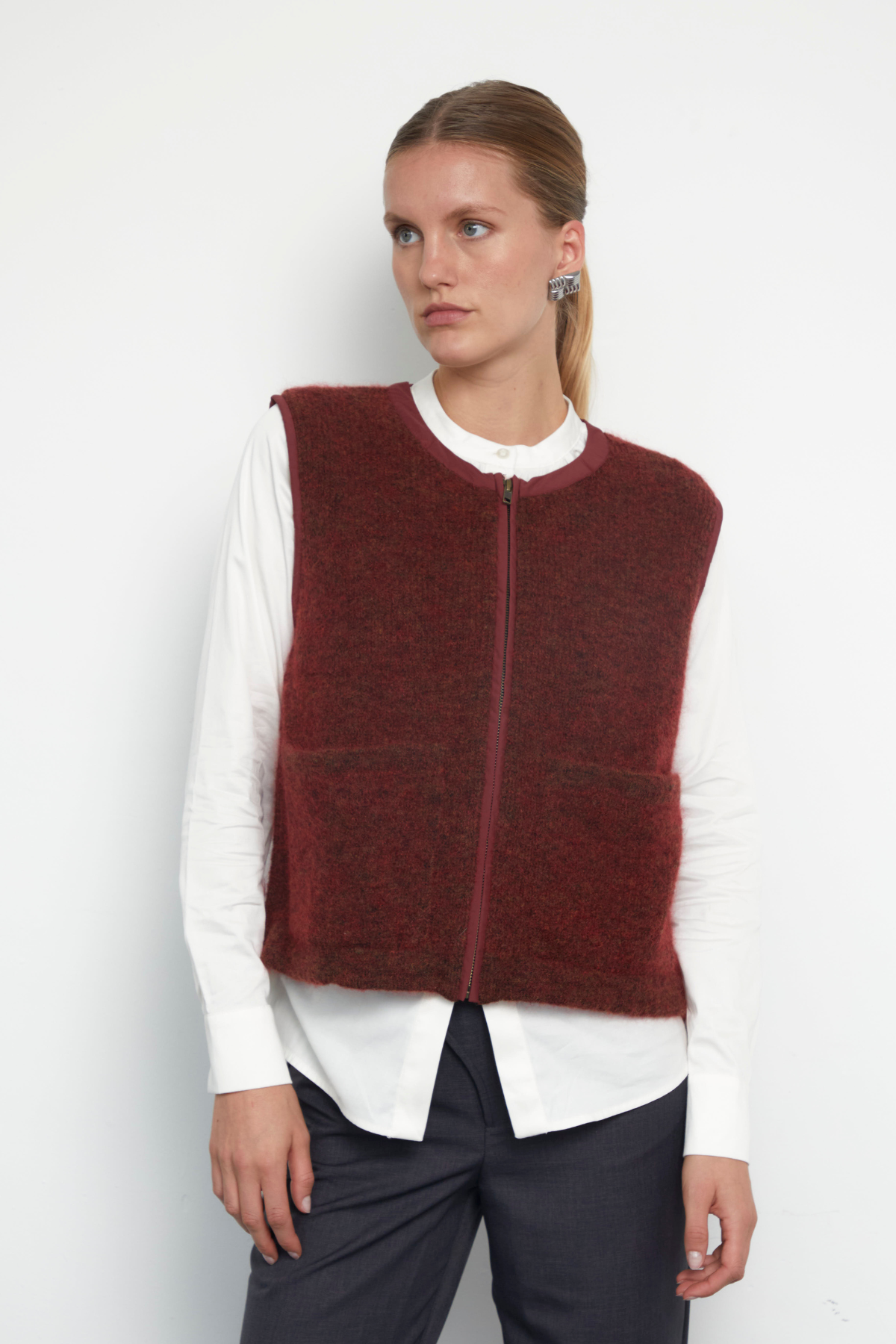 Burgundy sleeveless knit vest with zip front and patch pockets
