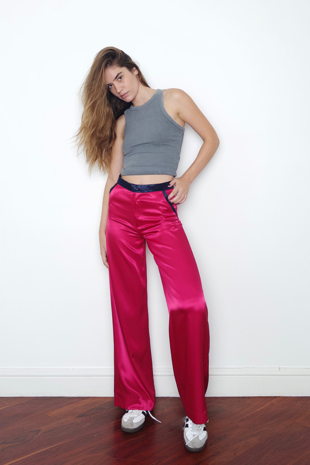 pink wide-leg silk trousers with navy trims, worn in London