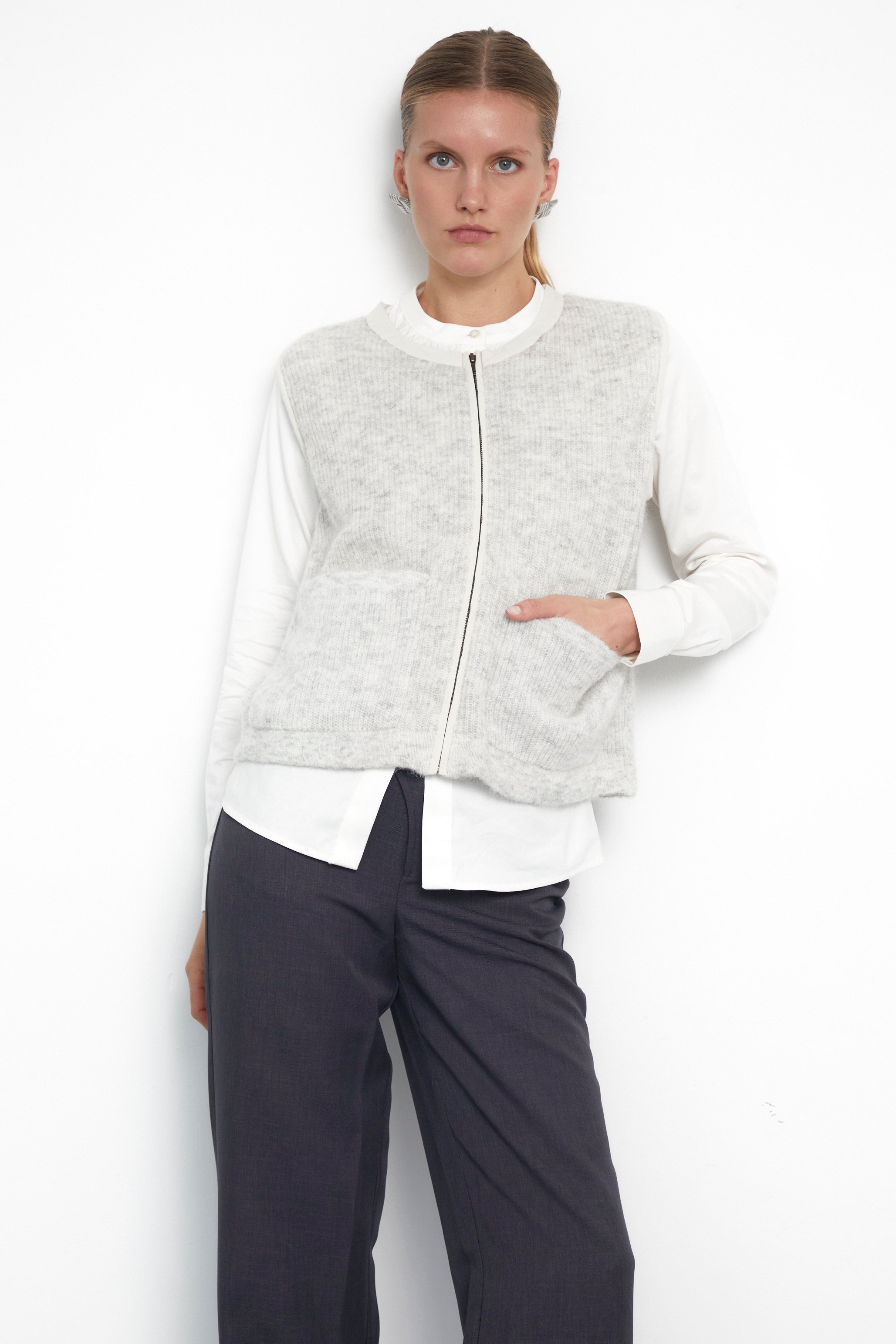 Light grey sleeveless knit vest with zip front and patch pockets